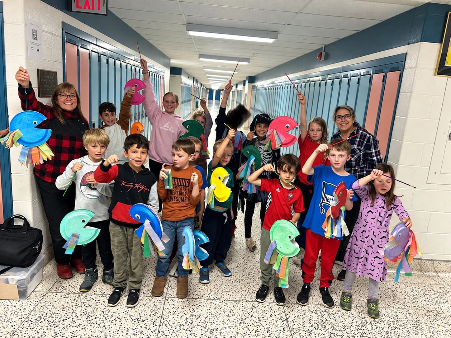 Children and teachers displaying colorful handmade lanterns in the school hallway