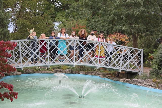 Children's choir students outdoors together near a bridge